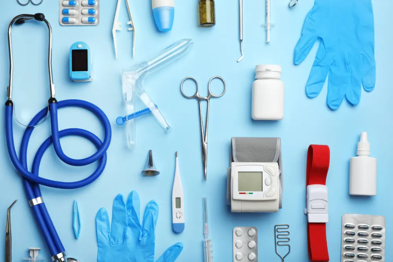 A blue table is filled with medical items like gloves,bandages,syringes, thermometers,stethoscopes