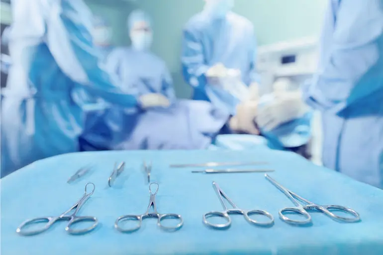 Surgeons performing a surgery using a variety of surgical tools in a well equipped operating room